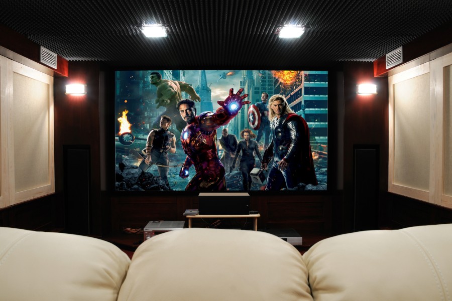 A spacious home theater featuring a large screen and a couch.